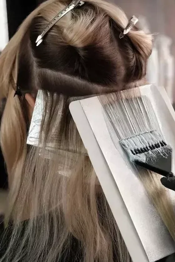Aplicação de mechas loiras em processo no salão