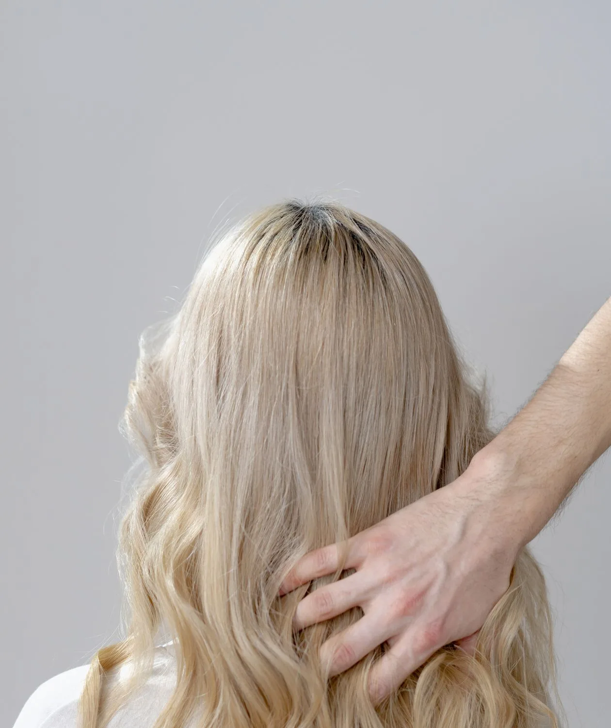 Detalhe de cabelo loiro saudável sendo penteado