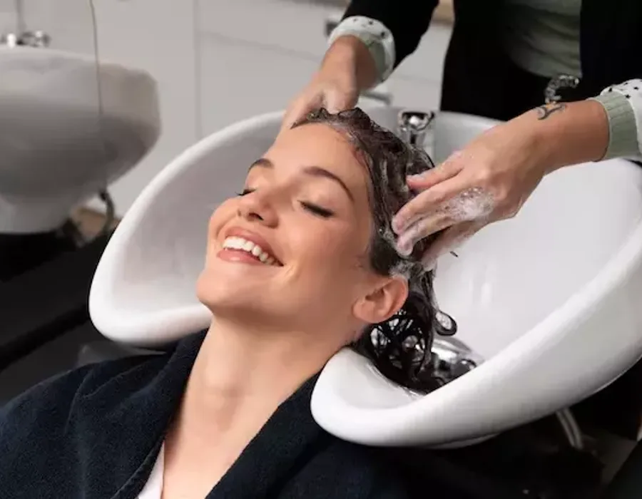 Cliente recebendo tratamento de reconstrução capilar na lavagem